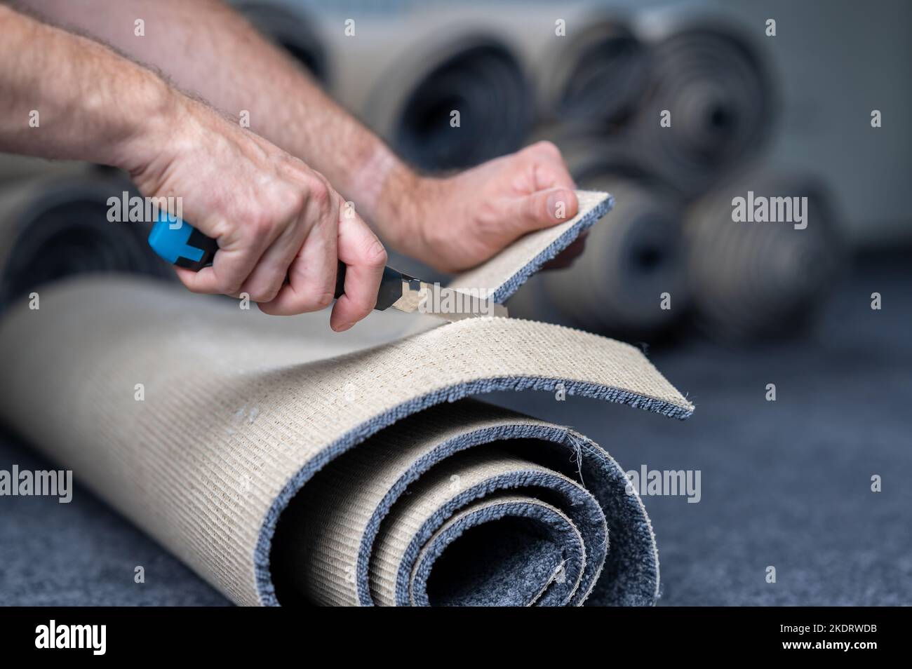 Handyman tagliare un nuovo tappeto con un tagliabordi Foto stock - Alamy