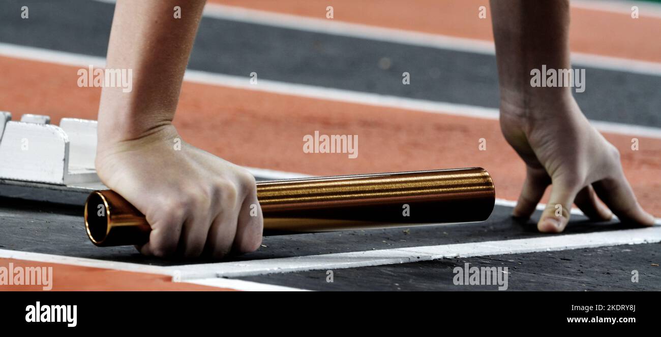 Runner che corre una corsa in pista con relè di baton per la squadra score competizione Foto Stock