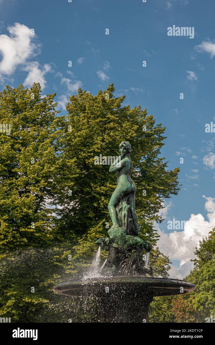Helsinki, Finlandia - 19 luglio 2022: Primo piano di una donna, la statua di Havis Amanda nella fontana e in Piazza del mercato a Kaartinkaupunki sotto il cielo blu. Verde fo Foto Stock