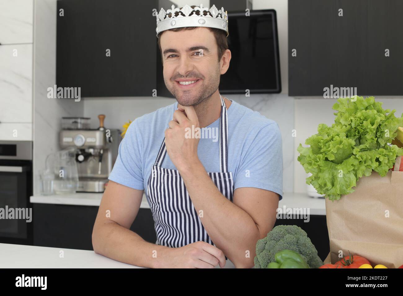 Uomo che indossa una corona in cucina Foto Stock