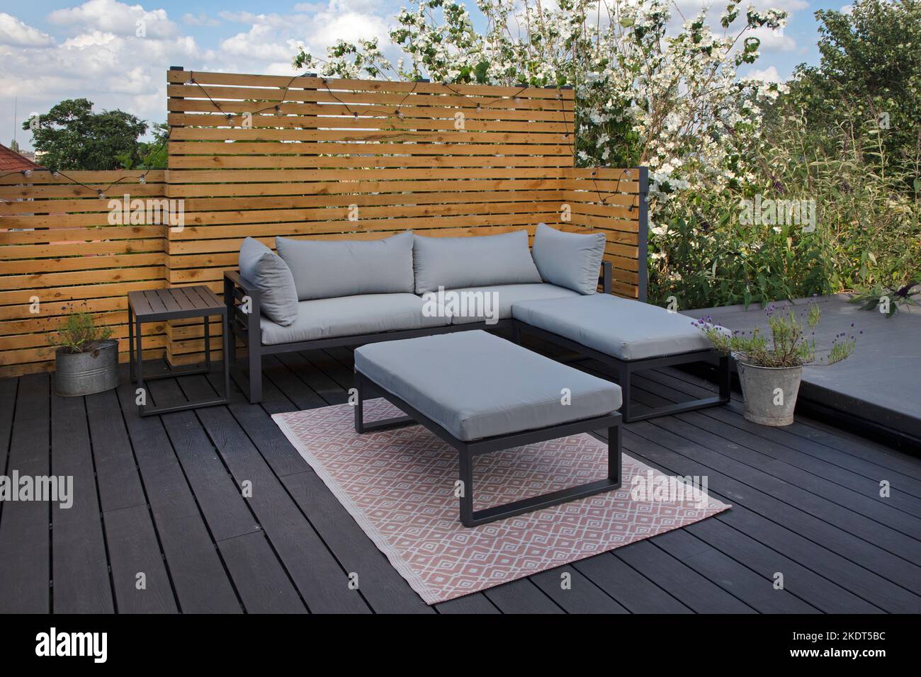 Posti a sedere in giardino contemporanei su moderne terrazze composite in giardino, Inghilterra Foto Stock