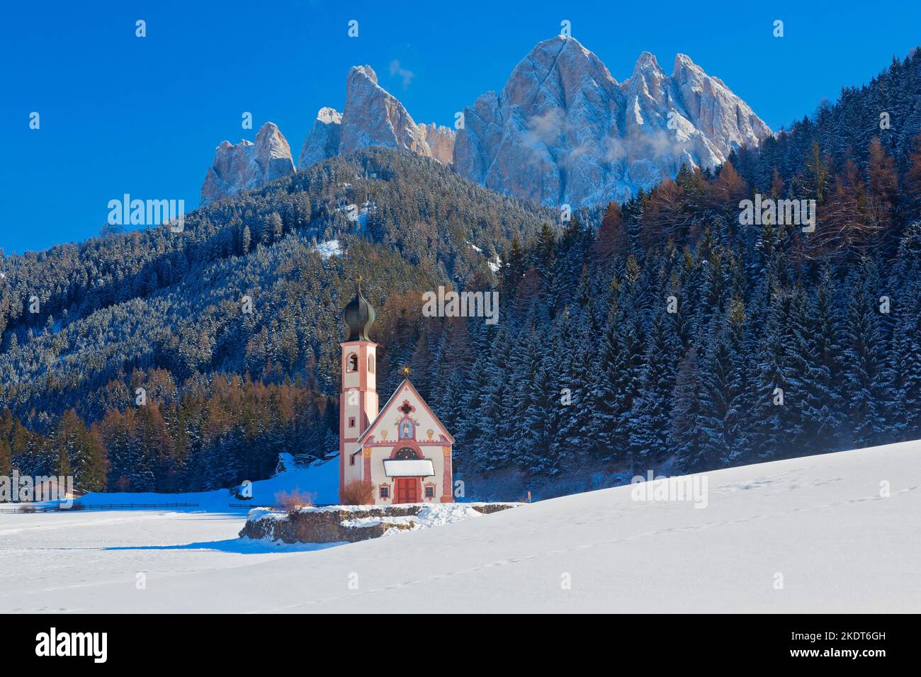 Veduta invernale della Chiesa di San Giovanni a Ranui con le Dolomiti di Puez-Odle, Villnoss Villnösser tal, Alto Adige, Italia Foto Stock