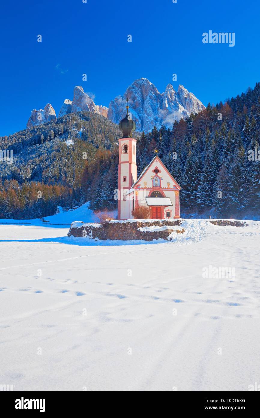Veduta invernale della Chiesa di San Giovanni a Ranui con le Dolomiti di Puez-Odle, Villnoss Villnösser tal, Alto Adige, Italia Foto Stock