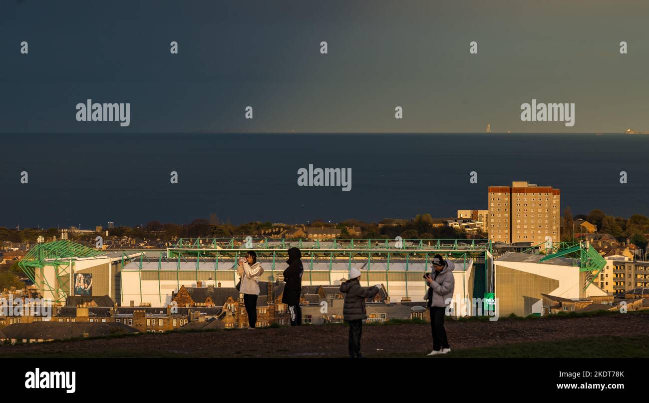 Calton Hill, Edimburgo, Scozia, Regno Unito, 8th novembre 2022. UK Weather: Sole e nuvole con i turisti che scattano foto della vista sul Firth of Forth con lo stadio Hibernian Football Club sullo sfondo. Credit: Sally Anderson/Alamy Live News Foto Stock