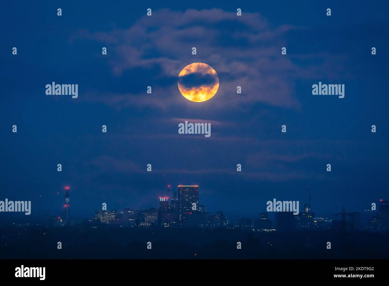 Birmingham, Regno Unito. 8th Novembre 2022. Il disco luminoso arancione della luna piena - o Beaver Moon di novembre - sorge sopra le luci della città nel tardo pomeriggio di Birmingham, Regno Unito. Credit: Peter Lopeman/Alamy Live News Foto Stock