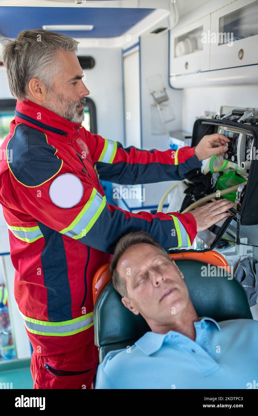 Paramedico professionale preparazione di un paziente per l'ossigenazione Foto Stock