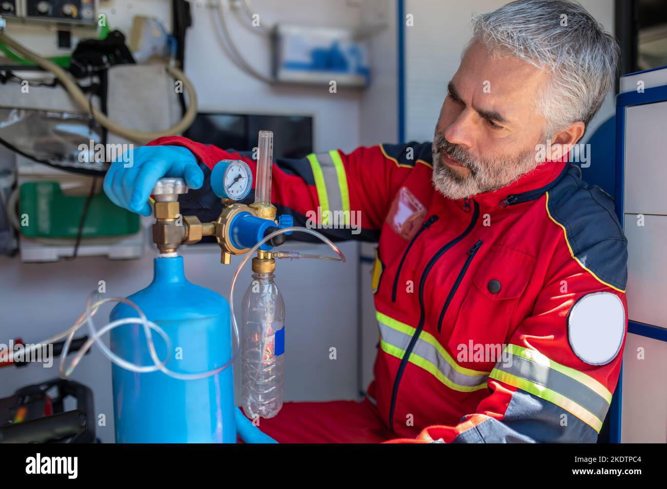 Medico di ambulanza messo a fuoco che usa l'apparecchiatura di ossigenazione Foto Stock