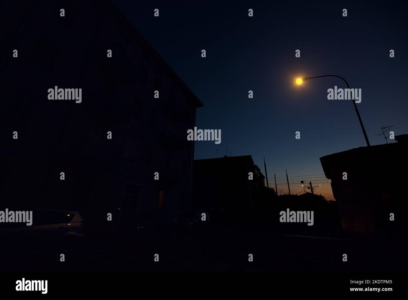 Attraversamento ferroviario in una città al crepuscolo Foto Stock