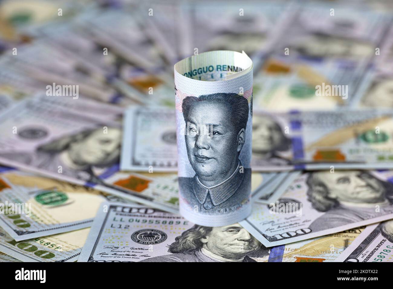 La banconota yuan cinese si è arrotolata su base di dollari americani. Concetto di guerra commerciale tra Cina e Stati Uniti, economico, sanzionatorio, turismo e investimenti Foto Stock