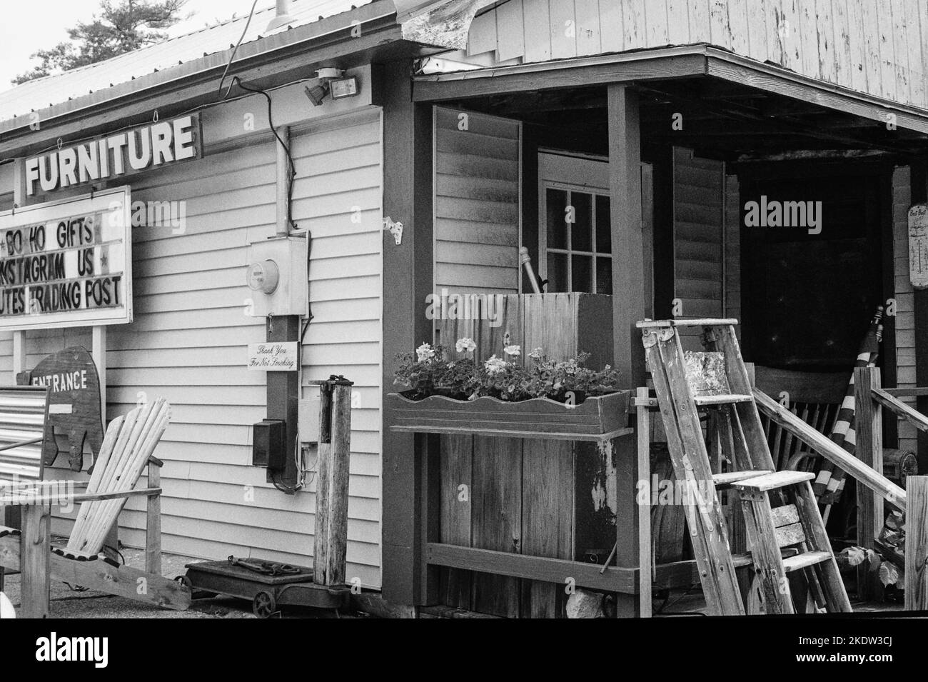 Scale di legno che conduce contro l'entance posteriore dei nutes Trading Post in Union, New Hampshire. L'immagine è stata acquisita su pellicola analogica in bianco e nero. Foto Stock