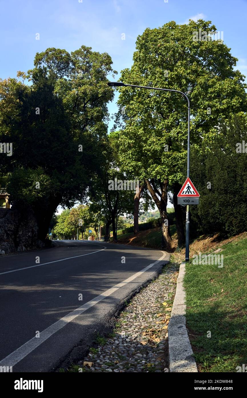 Strada in salita accanto ad un edificio in una città italiana Foto Stock