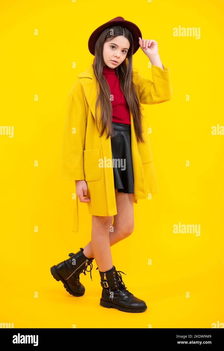 Moda voga teen. Foto a tutta lunghezza di bruna ragazza teen indossare casual cappotto autunnale isolato su sfondo giallo. Foto Stock