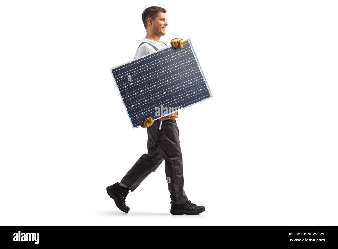 Foto a profilo completo di un tecnico che porta un pannello solare e cammina isolato su sfondo bianco Foto Stock
