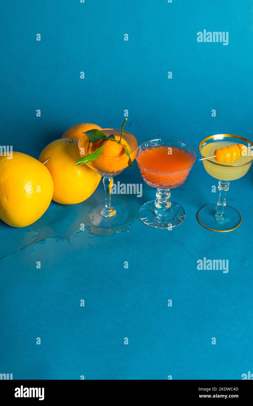 tre cocktail di agrumi, bevande su sfondo blu Foto Stock