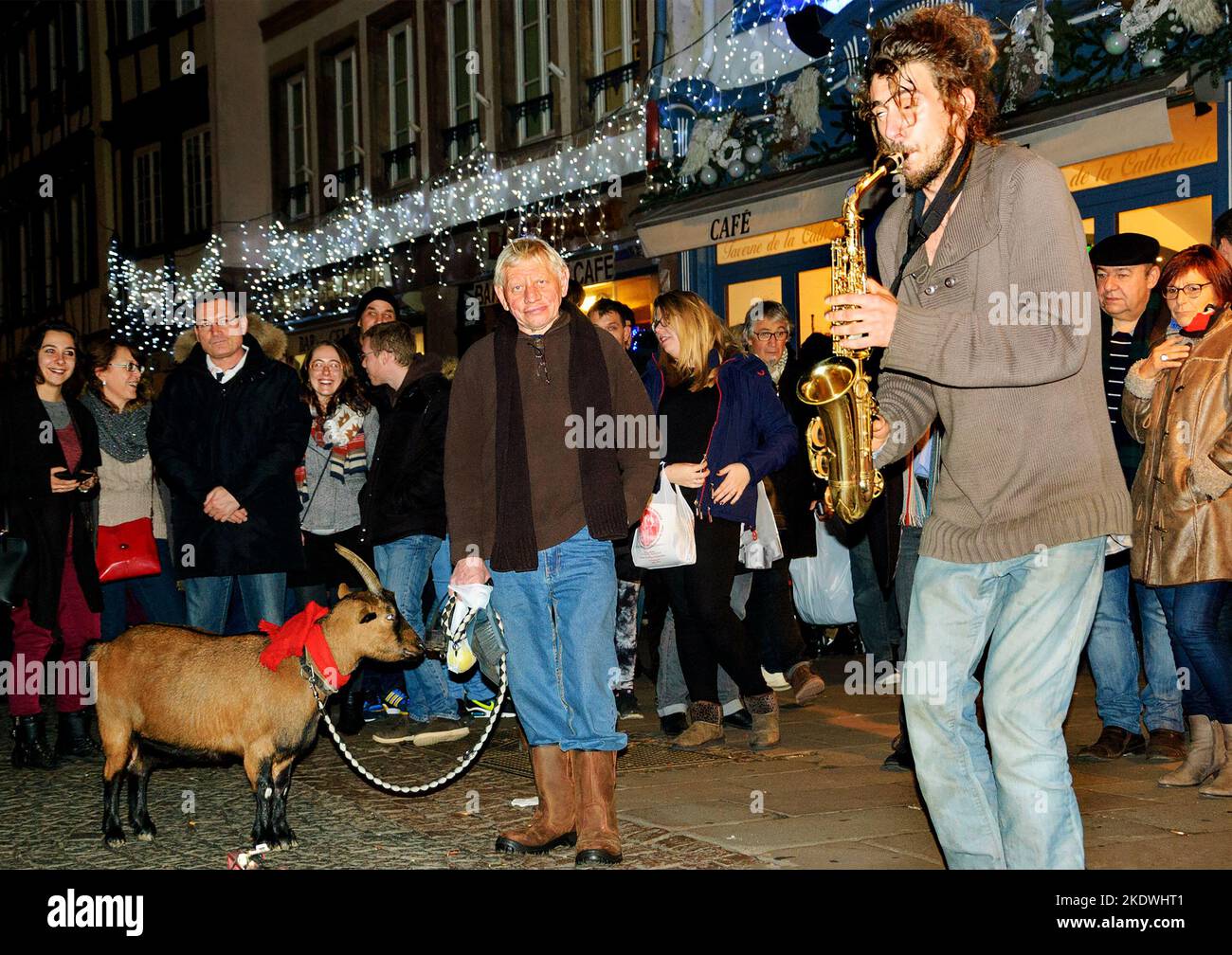 STRASBURGO, FRANCIA - 20 DICEMBRE 2015: Musicisti di strada e il pubblico (compreso un uomo con capra) al mercato di Natale a Strasburgo. Foto Stock