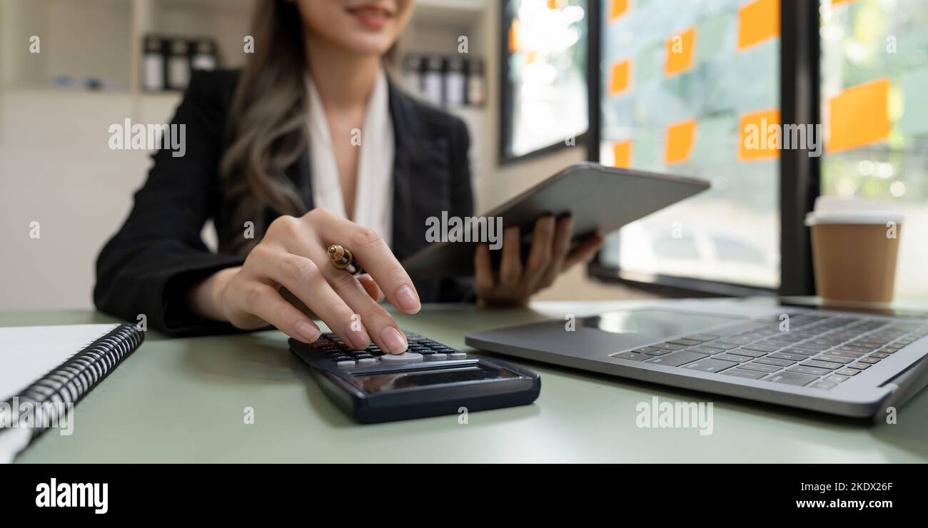 Primo piano un uomo che lavora su finanziario con calcolatrice presso il suo ufficio per calcolare le spese, concetto contabile. Foto Stock