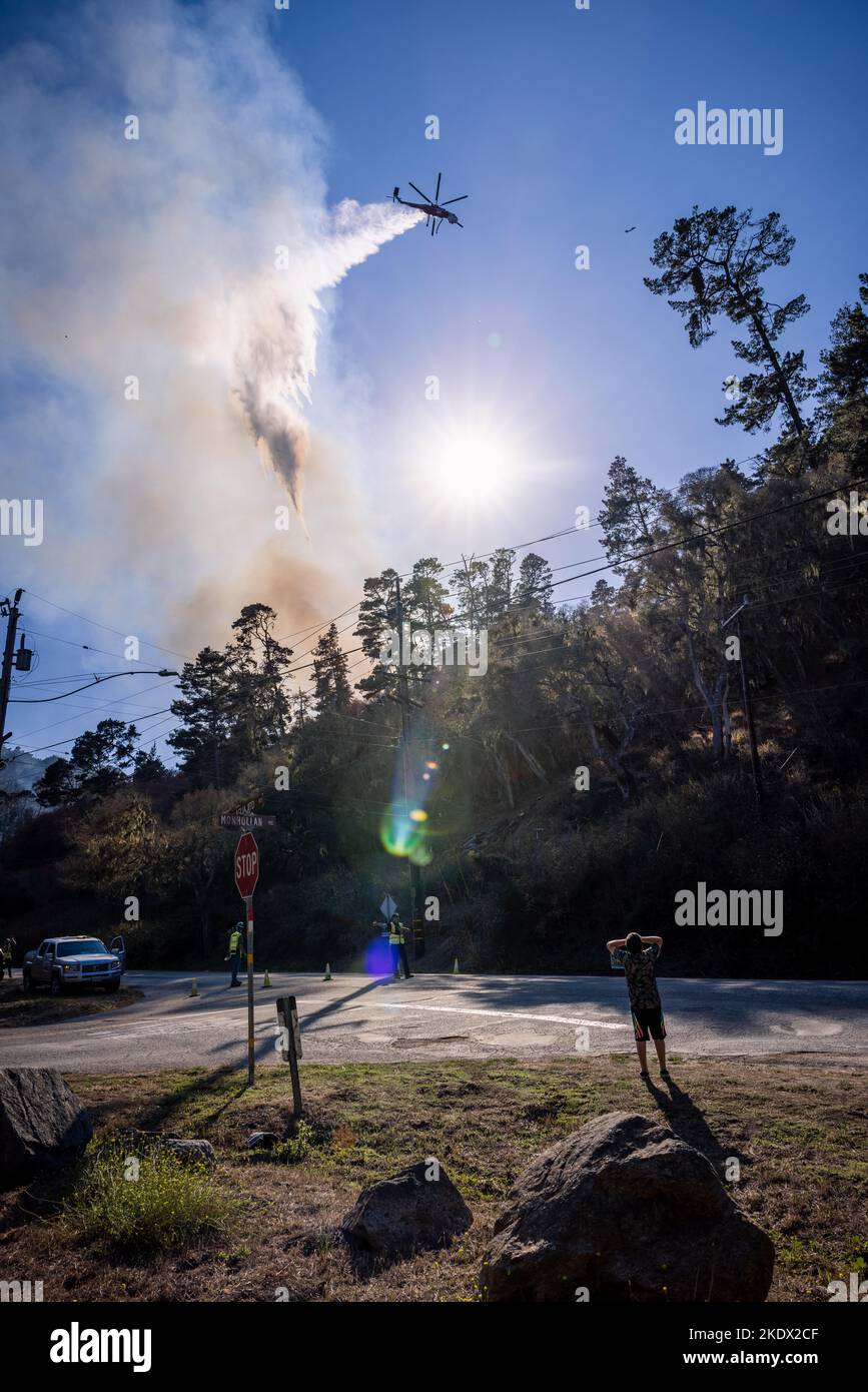 Gli astanti e i soccorritori guardano come un elicottero fa cadere l'acqua sul fuoco di Aguajito a Monterey, California Foto Stock
