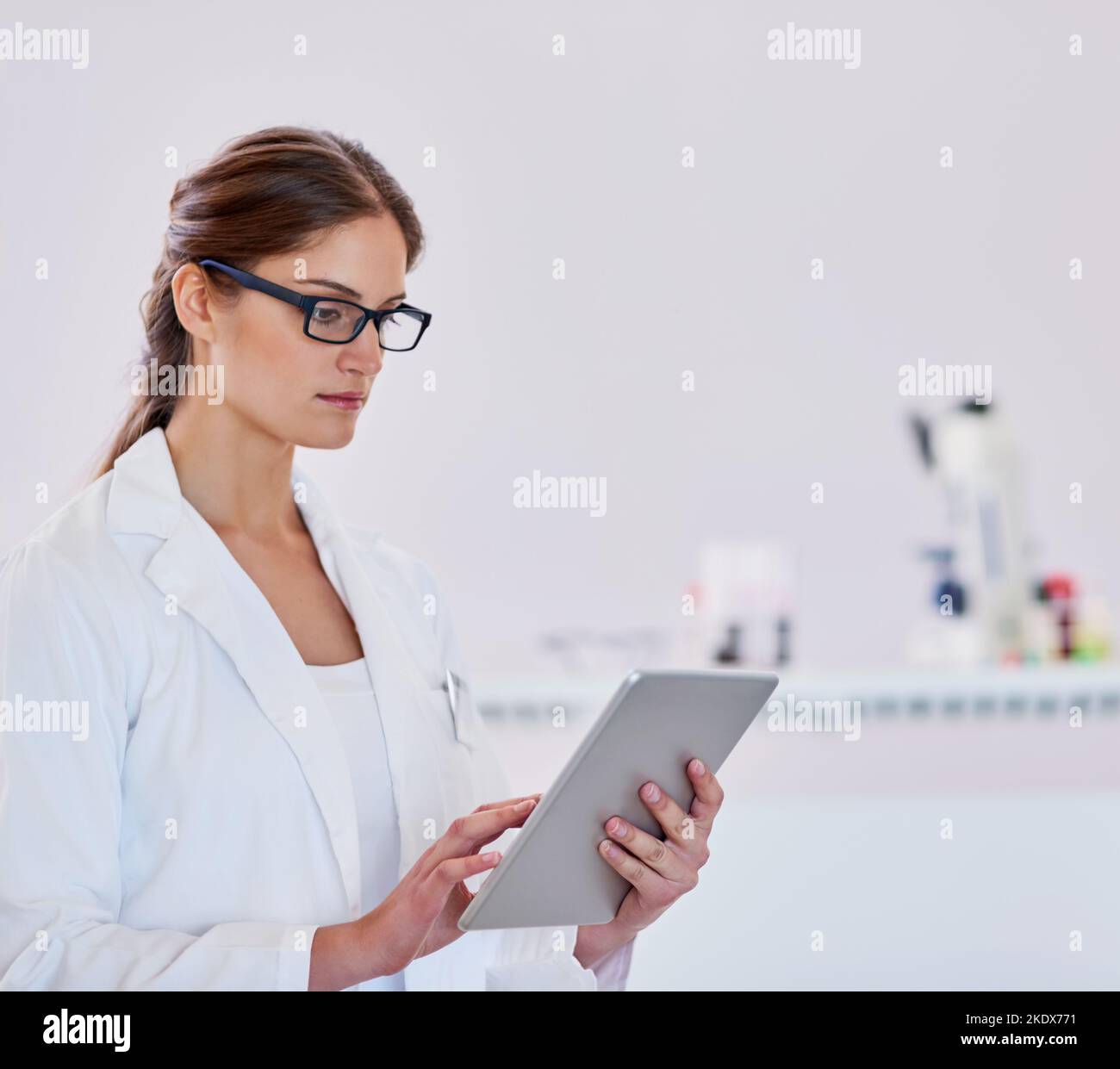 Registrazione dei risultati per ricerche future. Uno scienziato che utilizza un tablet digitale mentre si trova in un laboratorio. Foto Stock