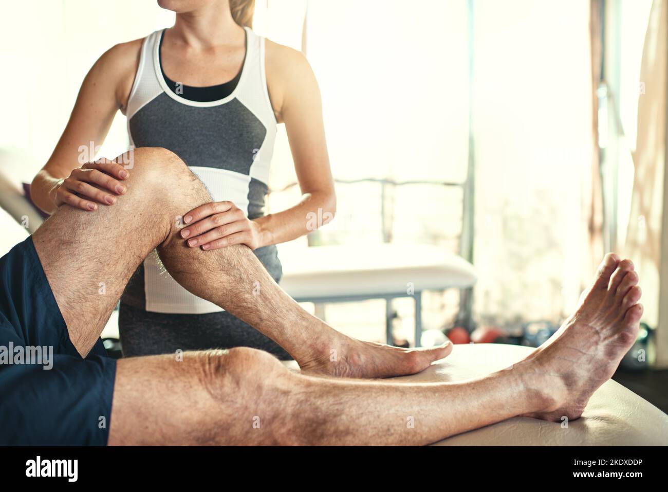 È un professionista pratico, un uomo che viene trattato da un fisioterapista. Foto Stock