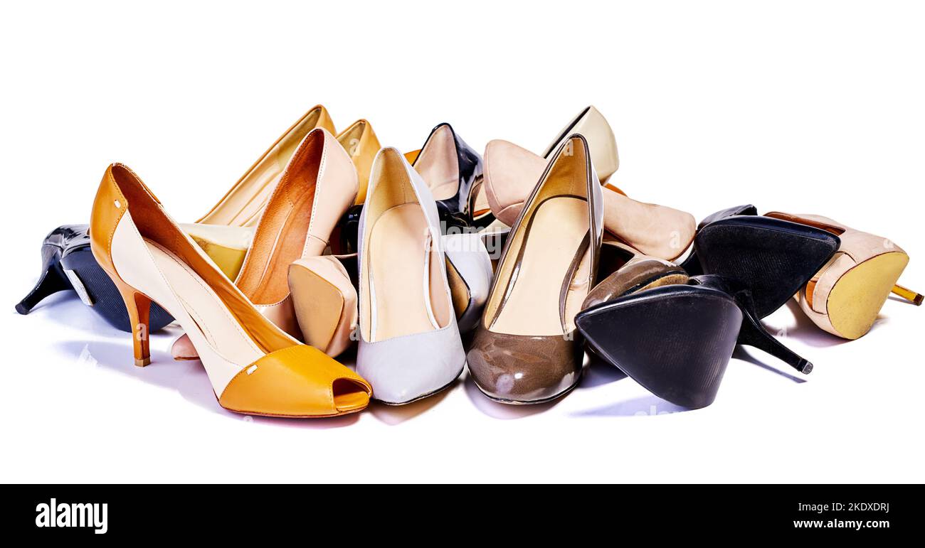 Non si può mai avere abbastanza scarpe. Primo piano di una selezione di scarpe con tacco alto in fila isolata sul bianco. Foto Stock