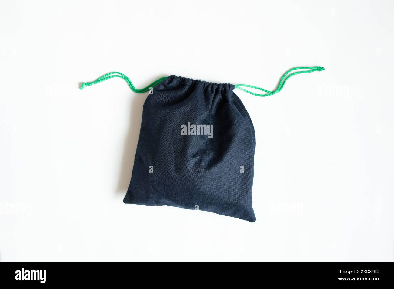 Una borsa in tessuto blu con stringhe si trova su uno sfondo bianco primo piano Foto Stock