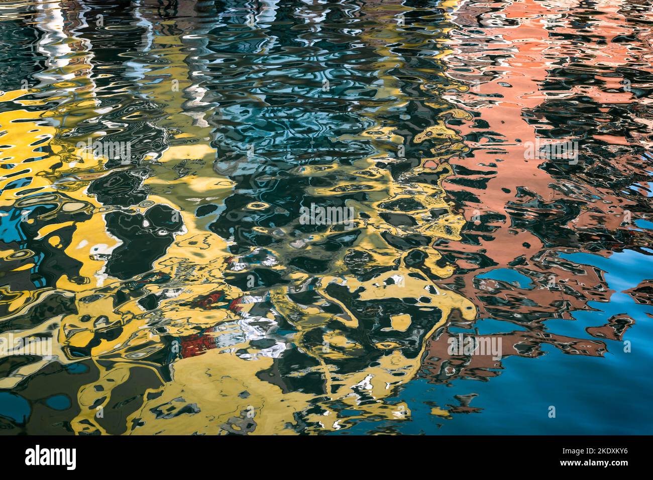 Riflessi colorati di edifici nell'acqua di un canale veneziano Foto Stock