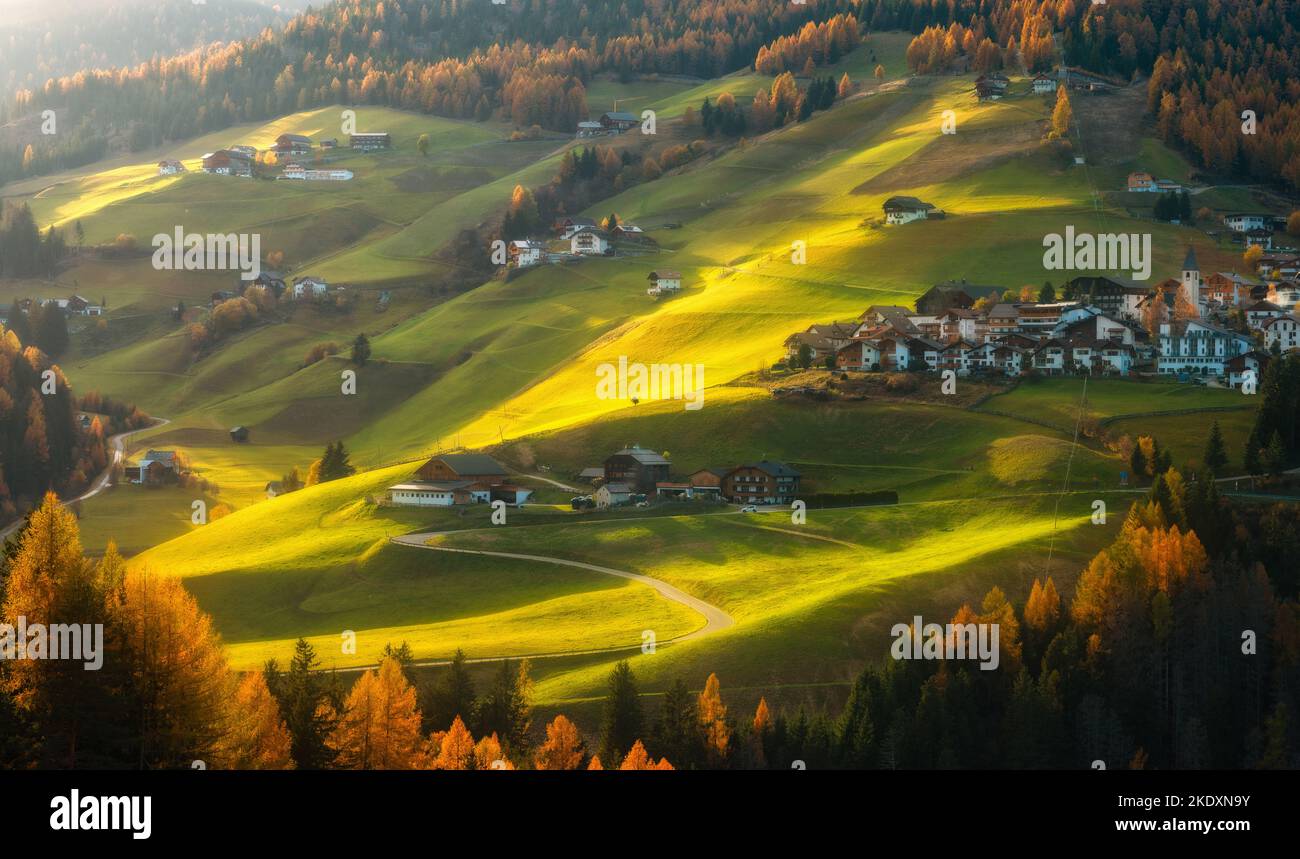 Bellissimo villaggio alpino sulle colline al tramonto in autunno Foto Stock