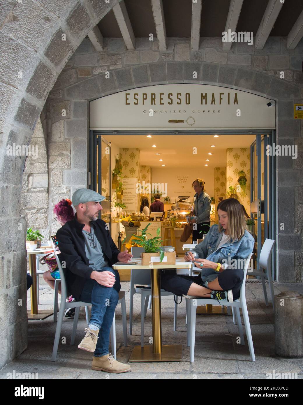Girona, Spagna - 21st ottobre 2022: Una coppia può godersi una pausa e un caffè fuori da uno dei numerosi caffè della città vecchia di Girona Foto Stock