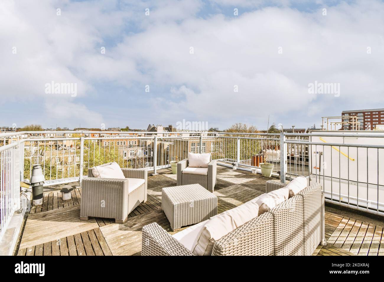 Pulito patio pavimentato, zona salotto e vista della città con alto sotto cielo nuvoloso Foto Stock