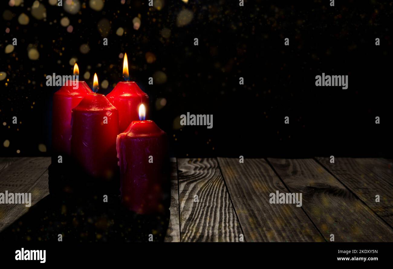 Tema dell'Avvento quattro candele rosse con sfondo scuro banner con luci misteriose. Foto Stock