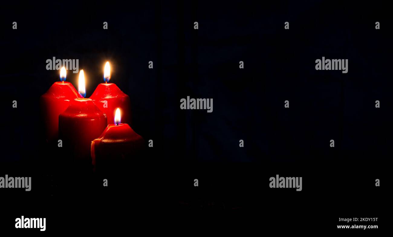Tema dell'Avvento quattro candele rosse con banner di sfondo scuro. Foto Stock