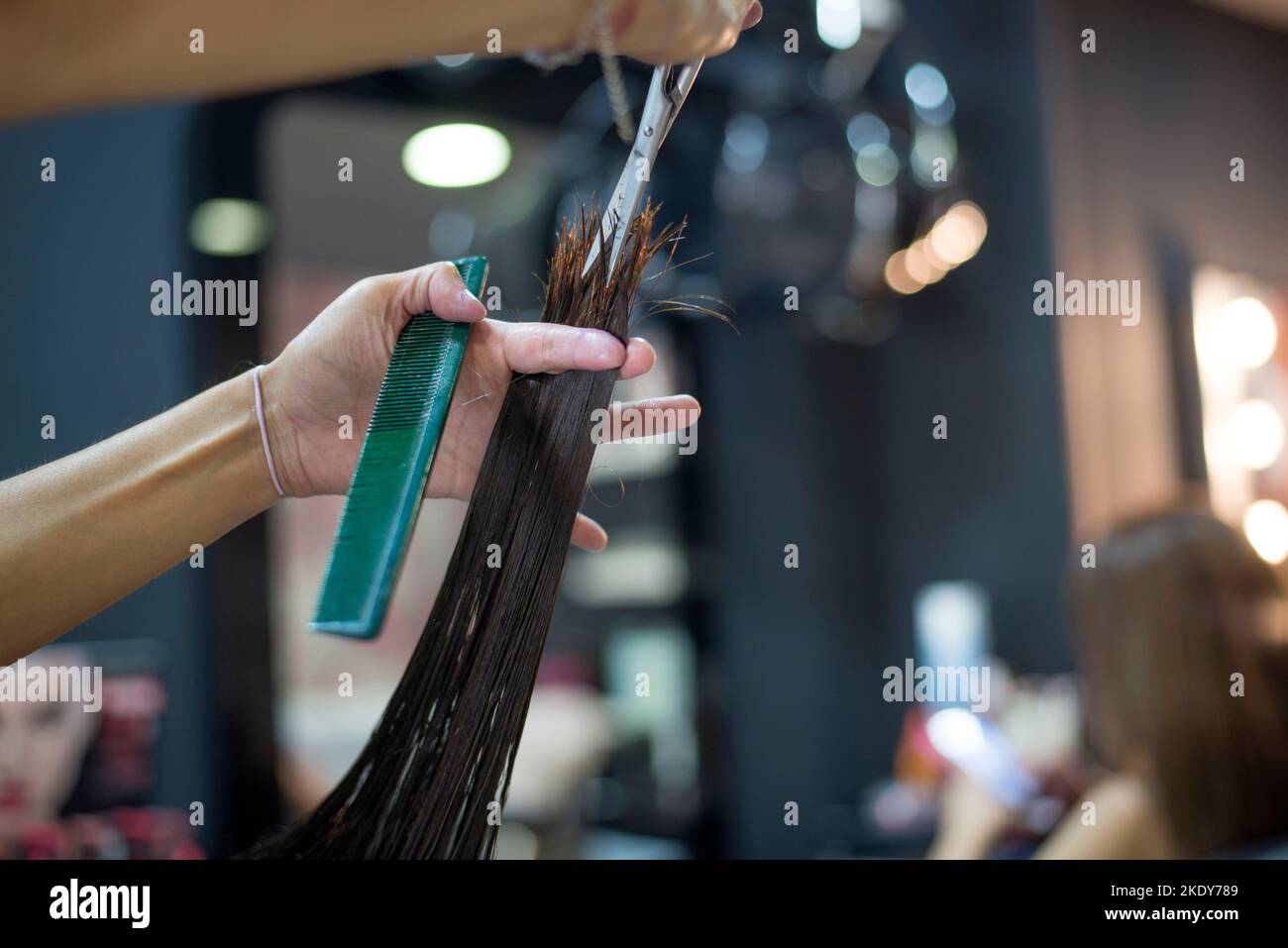 Il parrucchiere sta tagliando i capelli del cliente Foto Stock