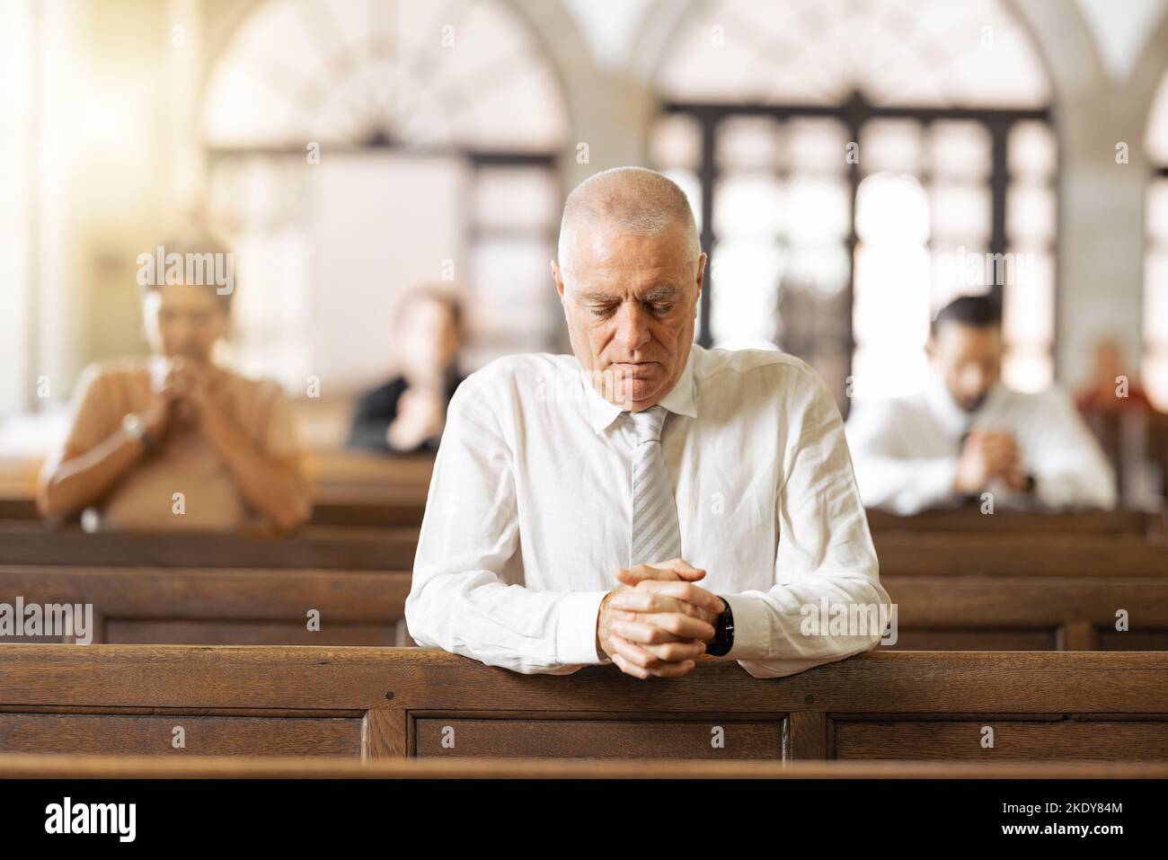 Pregare, fede e in chiesa per adorare, spirituale e religione con i credenti, la congregazione e il silenzio. Religiosi, si collegano e le mani insieme per Foto Stock