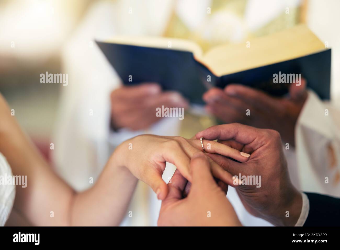 Coppia mani con anello, matrimonio e matrimonio in chiesa con il sacerdote e la bibbia nella cerimonia tradizionale. Impegno, amore e gioielli, uomo e donna Foto Stock