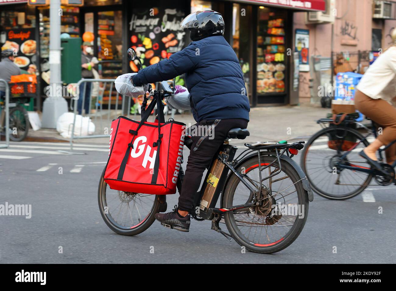 Una persona che consegna cibo Grubbhub su una bici elettrica a Brooklyn, New York Foto Stock