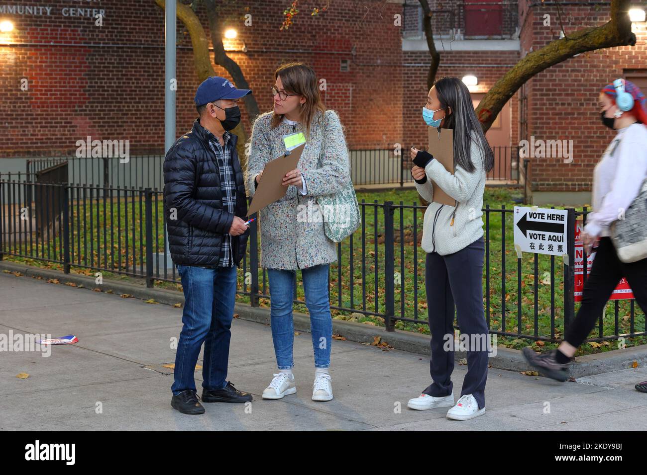 I volontari della Difesa legale e dell'Educazione Asiatica americana conducono un sondaggio di uscita fuori dal centro di polling di Manhattan Chinatown, New York, 8 novembre 2022. Foto Stock