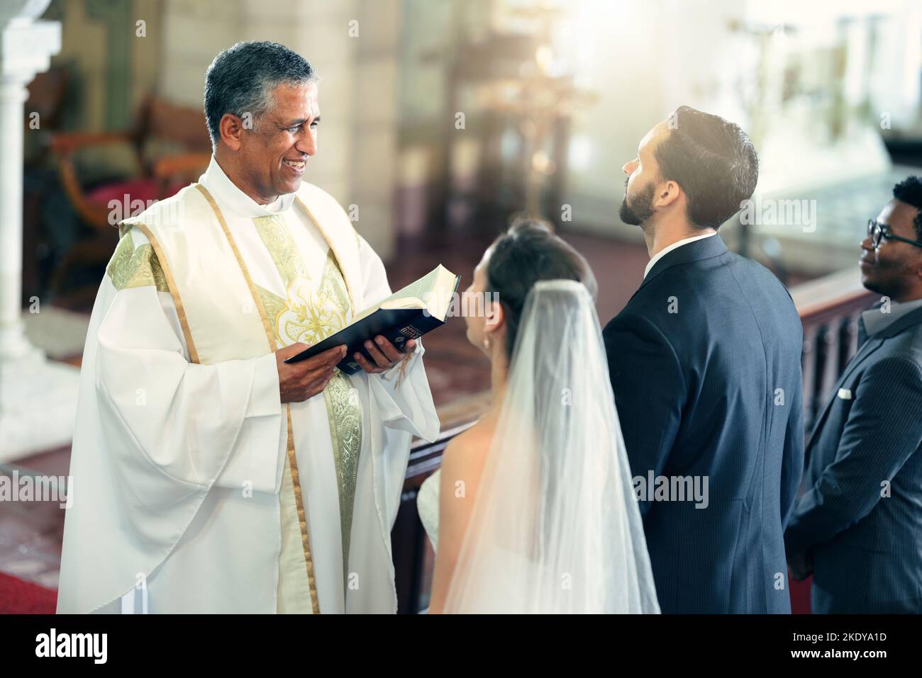 Matrimonio, coppia e sacerdote con una bibbia in chiesa che prega a Dio con un pastore cristiano che legge il libro santo. L'amore, la sposa e lo sposo dicono un giuramento per Foto Stock