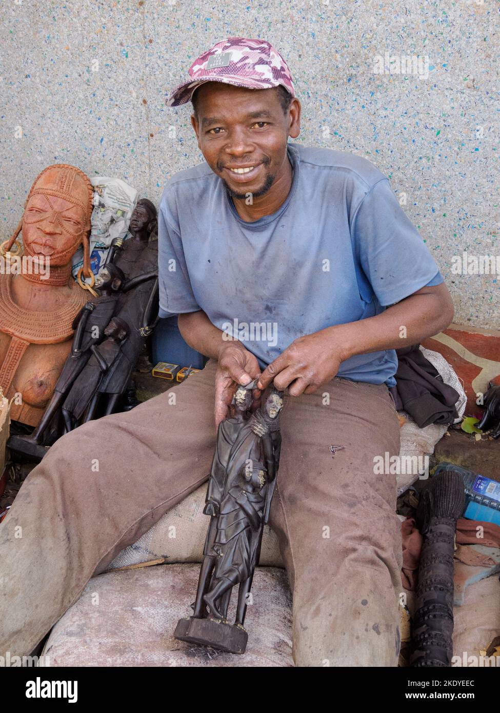 Artigiano che produce sculture in legno per il mercato turistico in un centro artigianale a Nairobi Kenya Foto Stock