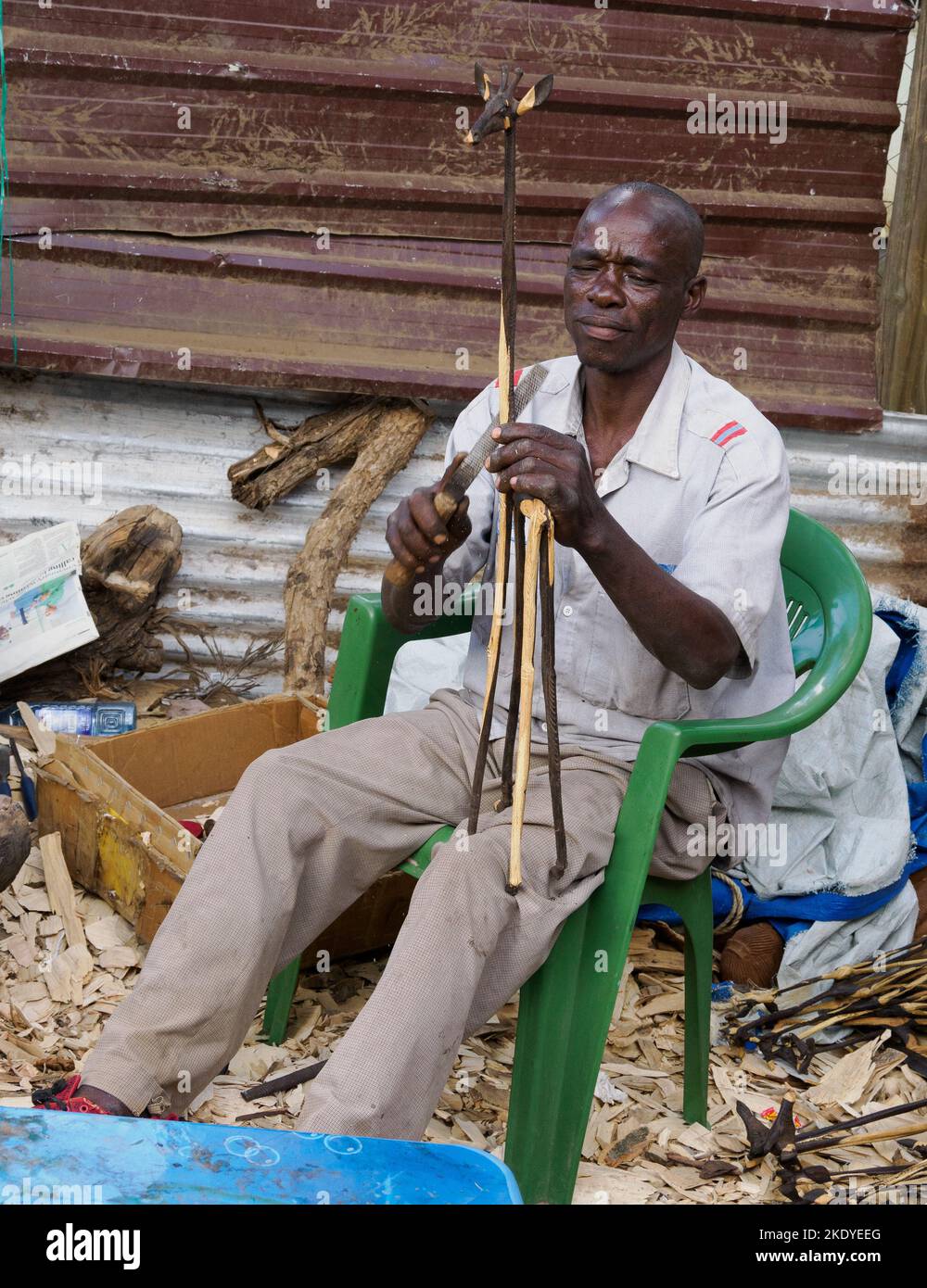 Artigiano che produce sculture in legno per il mercato turistico in un centro artigianale a Nairobi Kenya Foto Stock