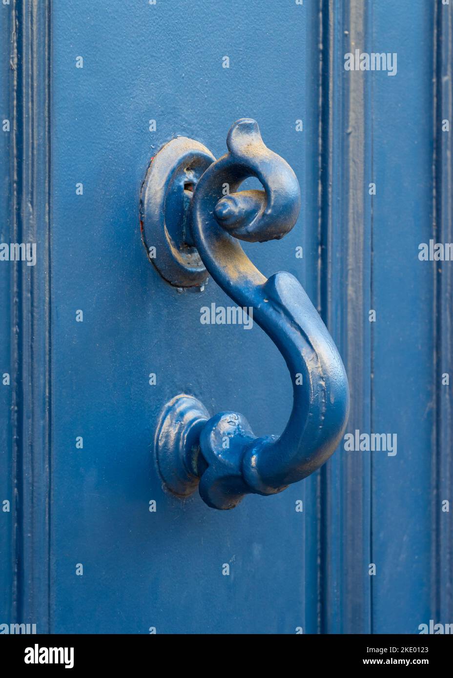 Vista in primo piano della maniglia in ottone vintage dipinto con bella patina isolato su antica porta in legno blu brillante, Montpellier, Francia Foto Stock