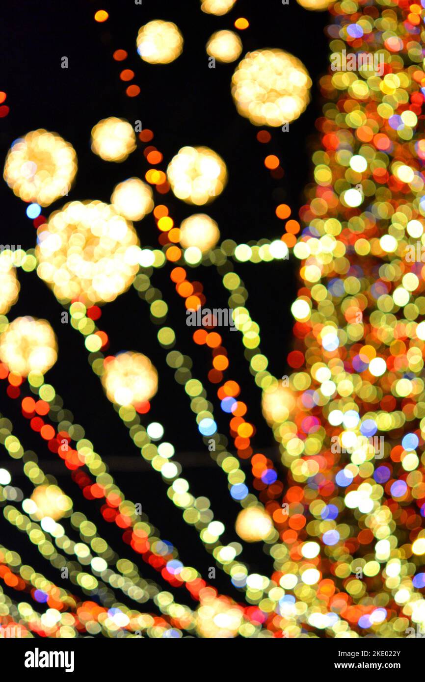 Albero di Natale di Capodanno decorato con luminose ghirlande multicolore e illuminazione notturna. Albero di Natale con luci lampeggianti. Sfondo sfocato. Capodanno vacanze di Natale. Foto Stock