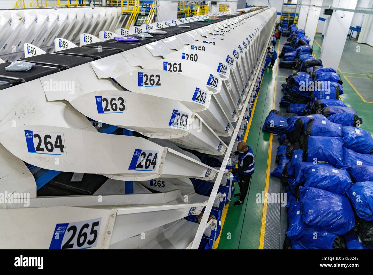 HEFEI, CINA - 9 NOVEMBRE 2022 - i lavoratori lavorano di fronte ad una linea di smistamento espresso completamente automatizzata presso un'impresa di consegna espressa a Hefei, Anhui pr Foto Stock