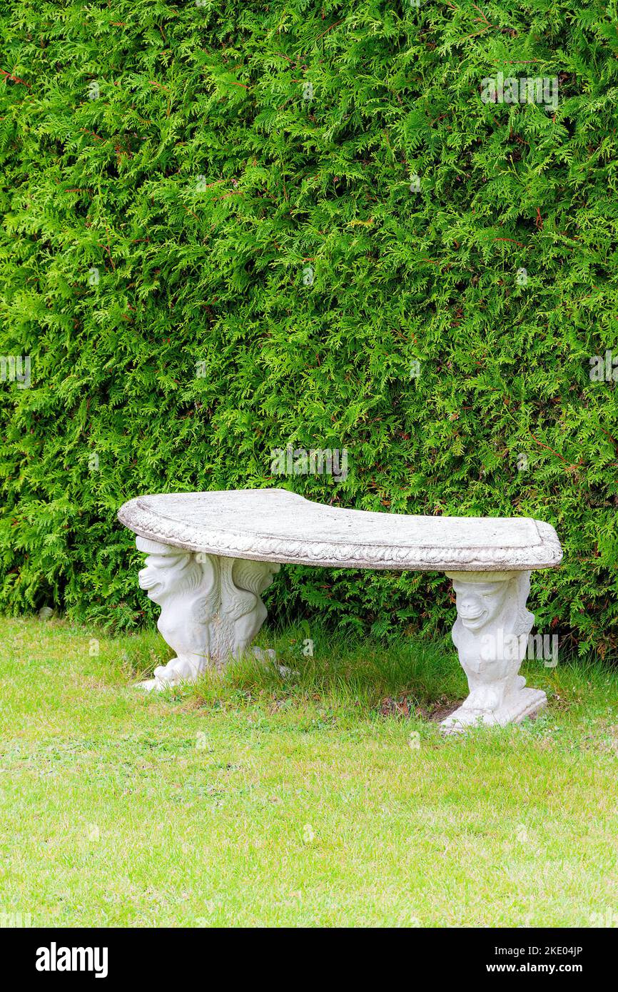 Panca in pietra semicircolare decorata per un giardino Foto Stock
