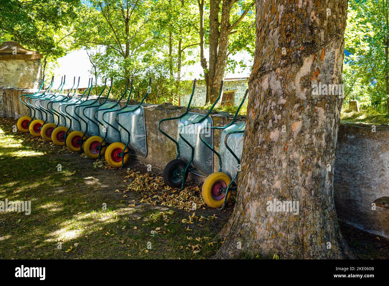 Carriole con ruote gialle allineate contro un muro Foto Stock