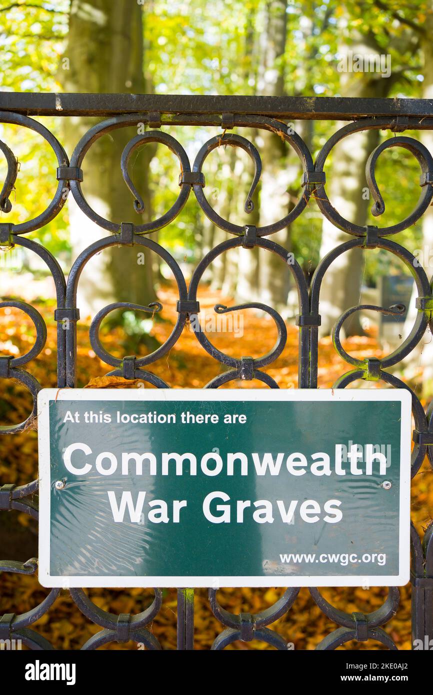 Cimitero di guerra Commonwealth posizione tombe. Guardando attraverso cancelli d'acciaio ornati in un giorno di autunno soleggiato. Foto Stock