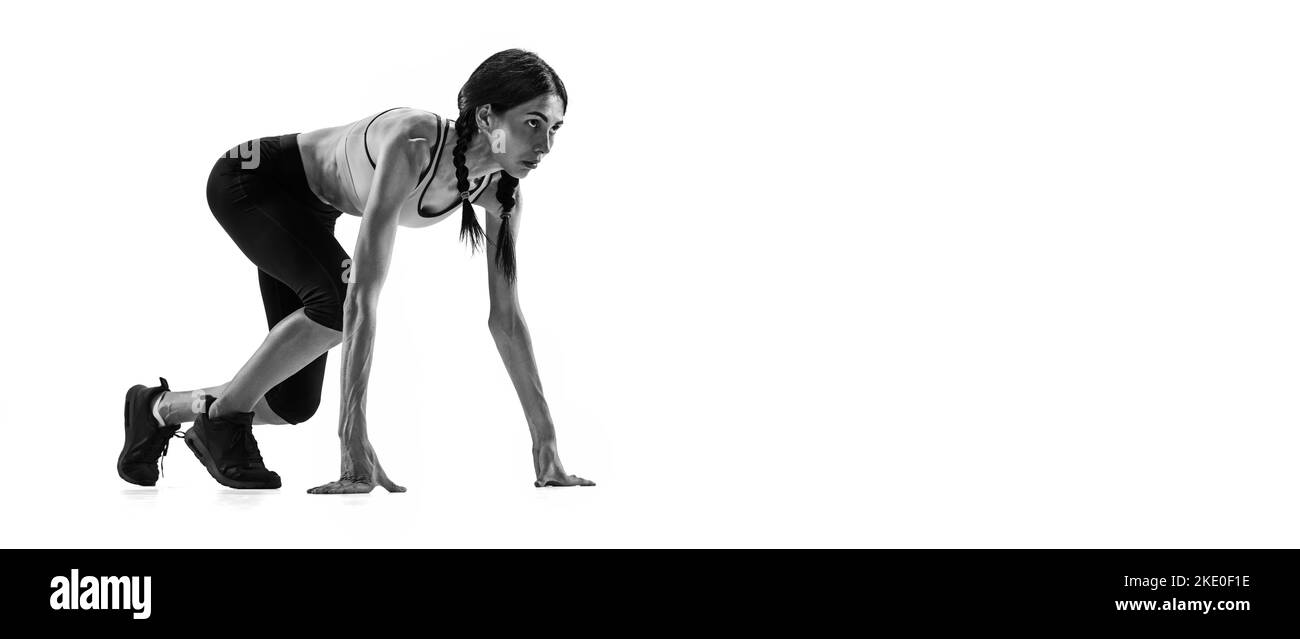 Avvio. Ritratto in bianco e nero di atleta professionista, runner, jogger in azione isolato su sfondo bianco. Monocromatico. Sport, bellezza Foto Stock