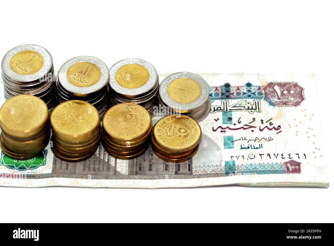 Pila di 100 EGP LE cento sterline egiziane banconote con pile di 1 LE EGP una libbra monete e 50 cinquanta piasters mezzo una libbra monete isolat Foto Stock