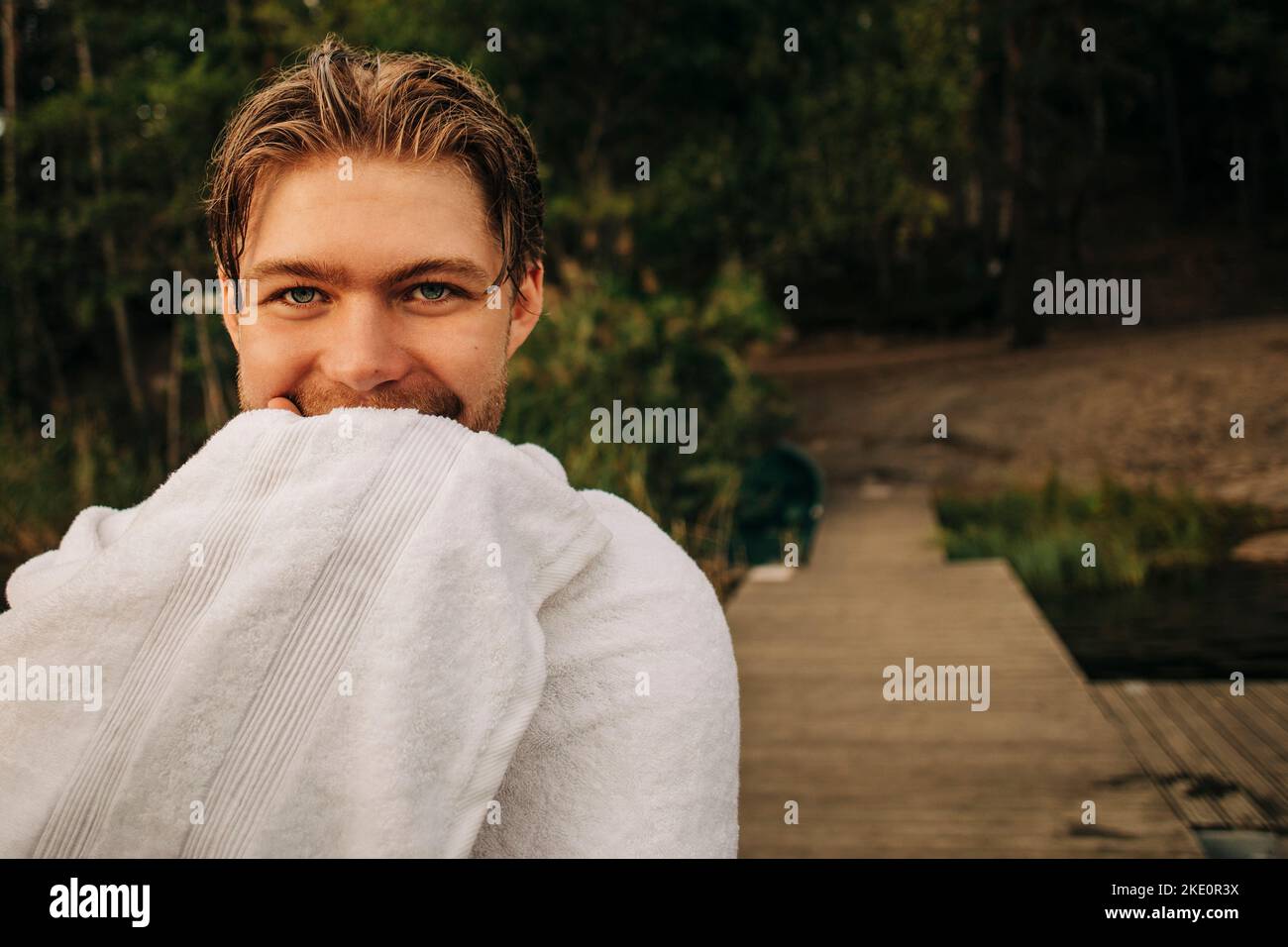 Ritratto di uomo sorridente avvolto in asciugamano Foto Stock