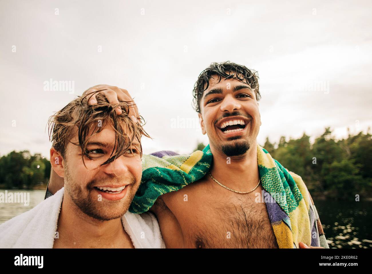 Ritratto di uomo felice con asciugamano da amico maschio durante la vacanza Foto Stock