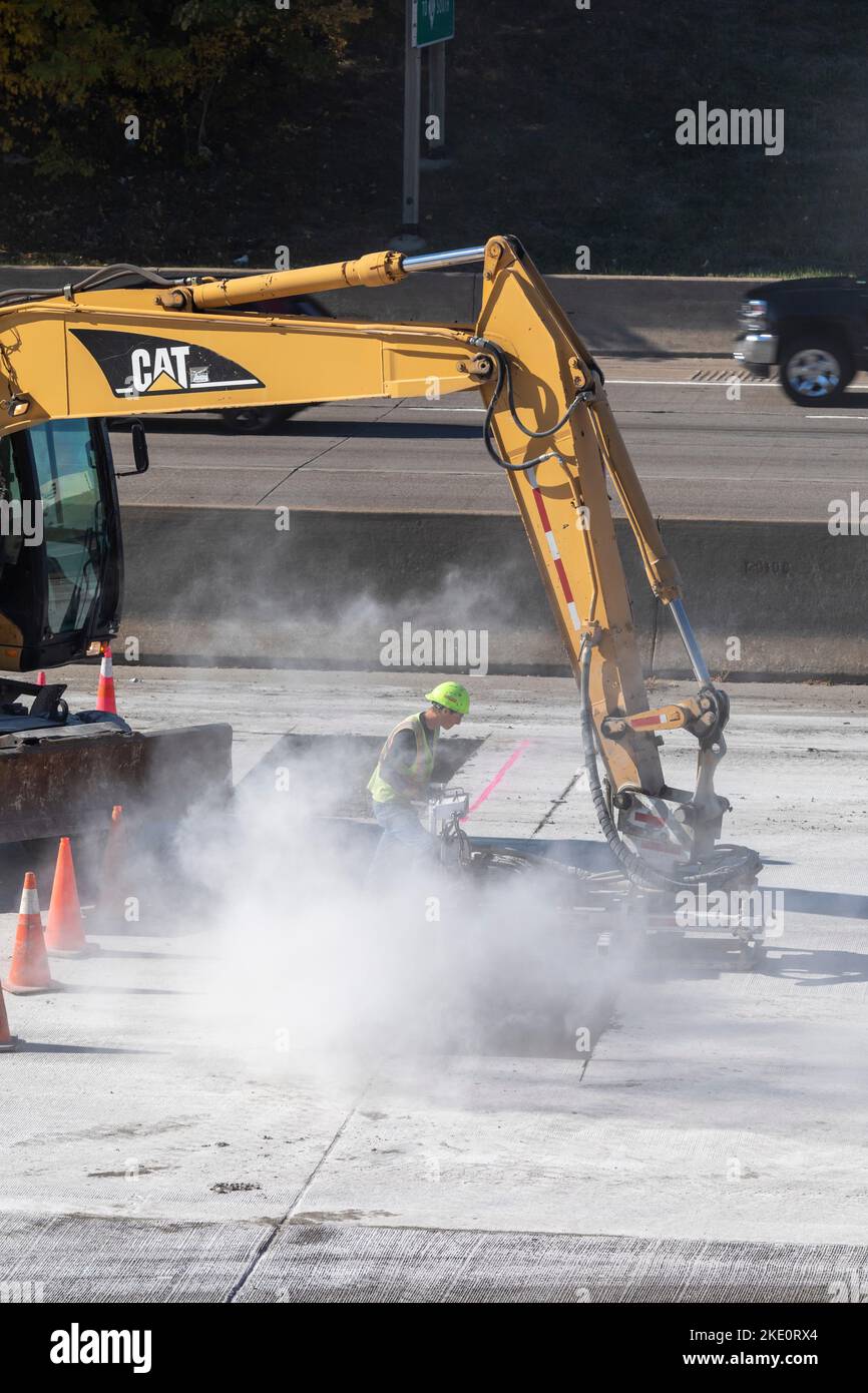 Detroit, Michigan - Un lavoratore è avvolto in polvere mentre lavora per riparare e riparare il cemento sulla Interstate 75. Foto Stock